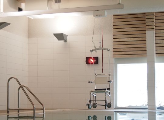 Hoisting chair suspended from overhead lifter